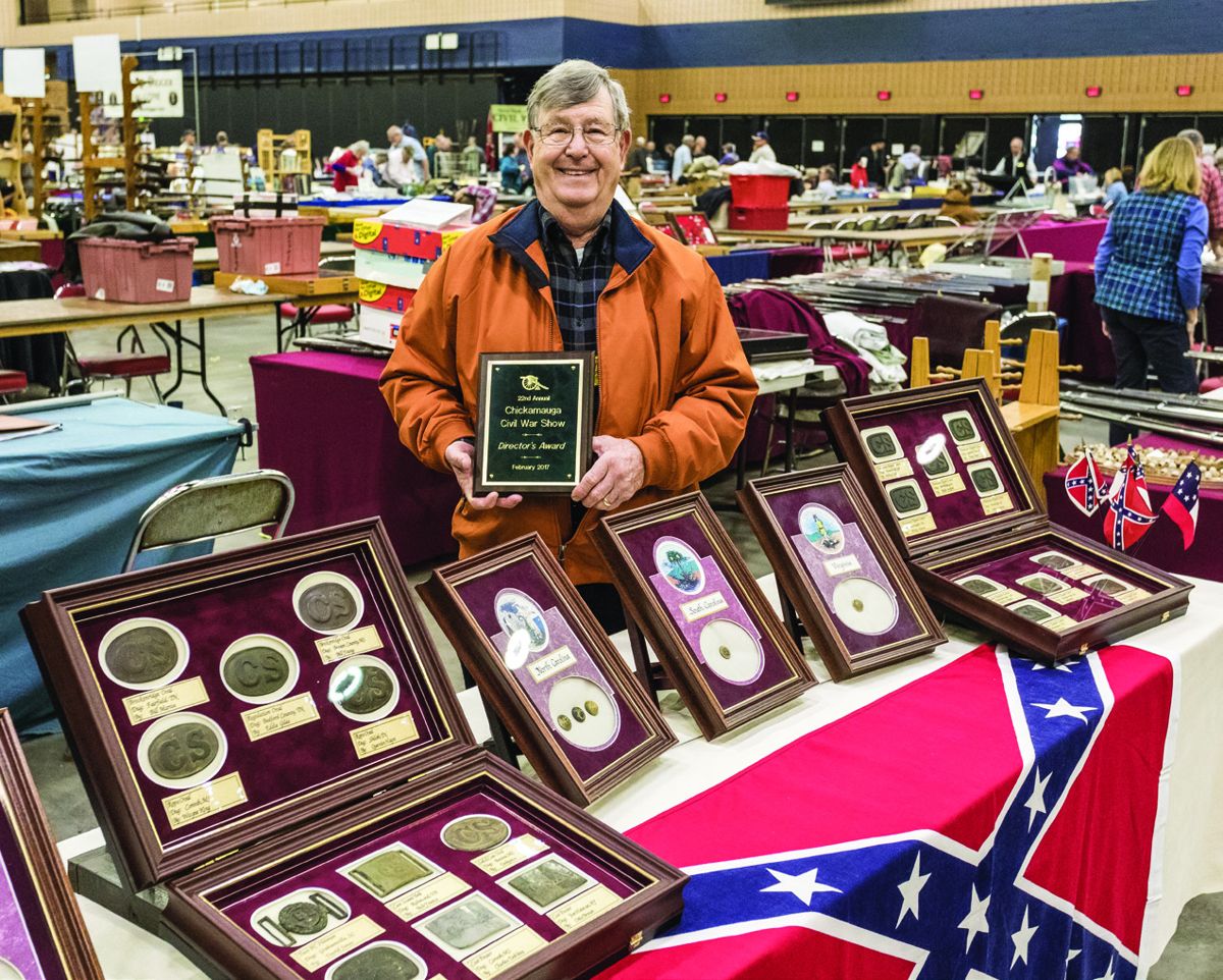 Jerry Hayes smiling as he holds his Director’s Award for his display of Confederate issued belt buckles.