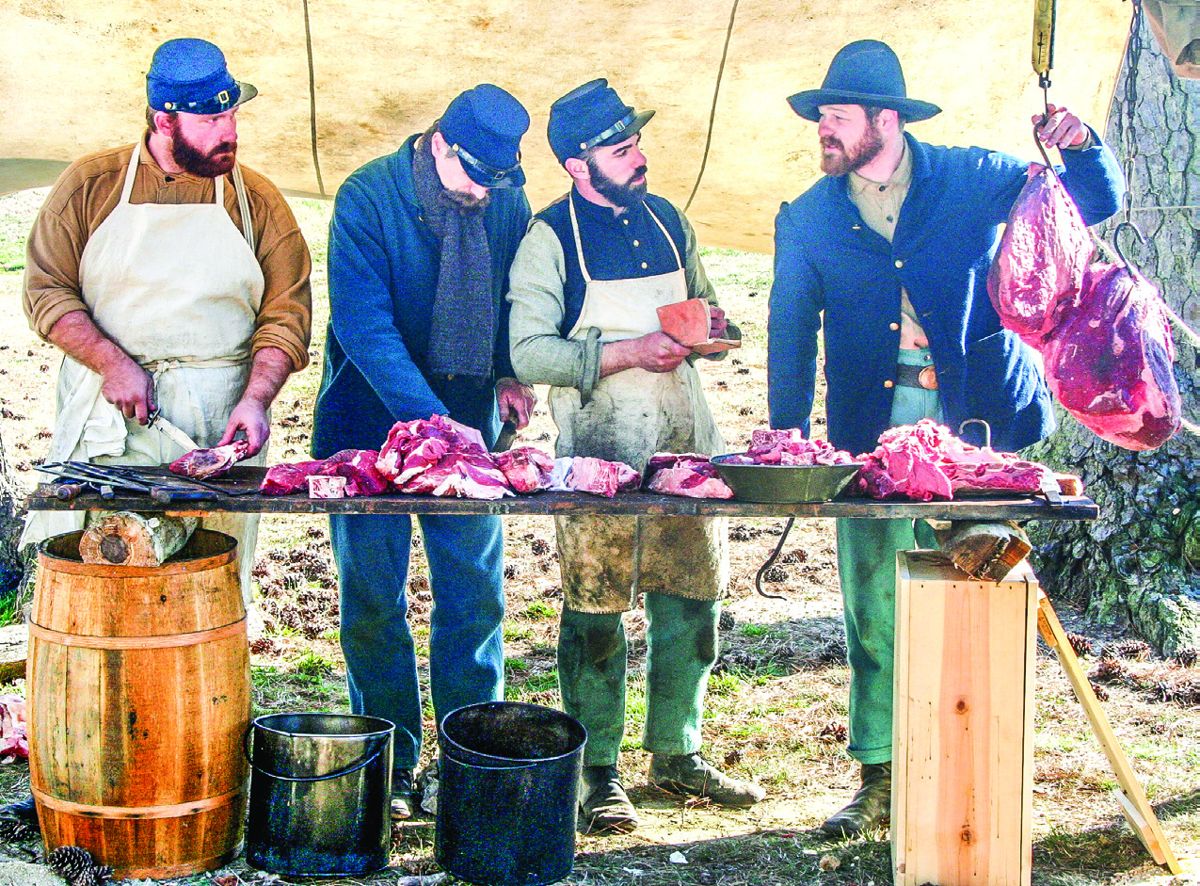 Charlie Thayer, George Taggart, Cody Harding, and Joey Frutchey butcher beef for the soldiers’ rations. (John Peterson)