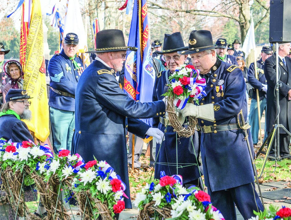 Major Alan Teller (left) Commander of the SVR 3rd Military District and Brig. Gen. Henry Shaw, Jr. (center) SVR Deputy Commander assist SVR National Commander Major Gen. Robert E. Grim (right) in placing a wreath during the GAR memorial service.
