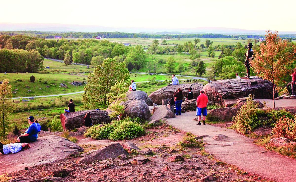 Visitors wait for sunset atop Little Round Top at Gettysburg National Battlefield Park.
