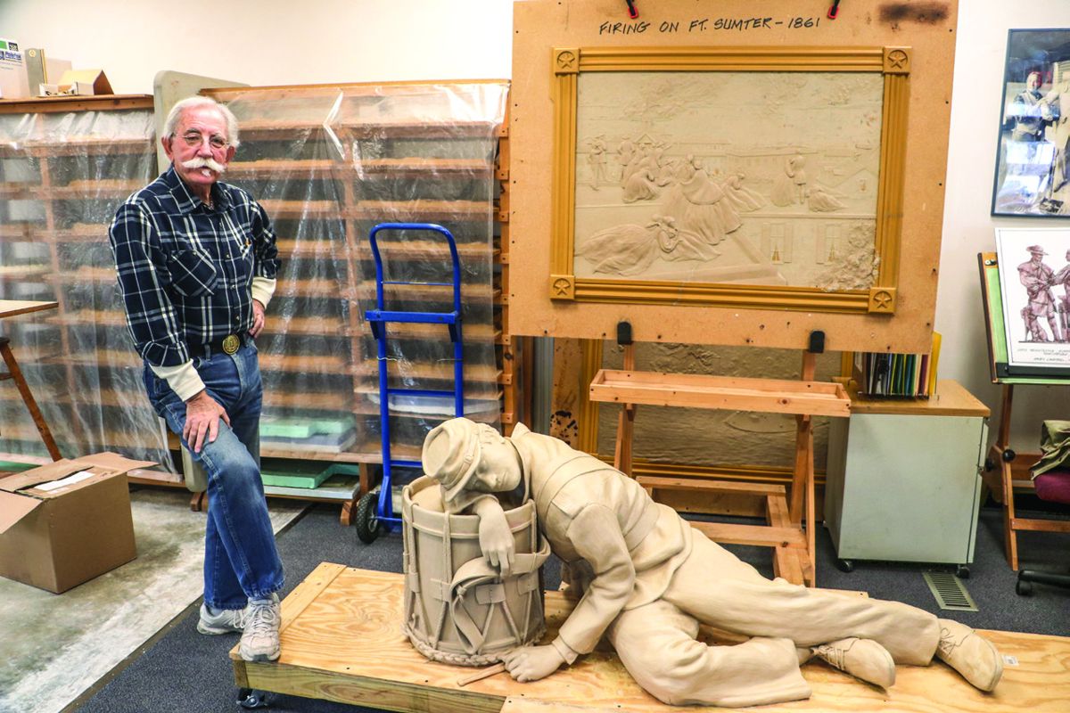 Gary Casteel standing next to the clay mold for “The Drums of War Are Sleeping” (front) and other parts of National Civil War Memorial.