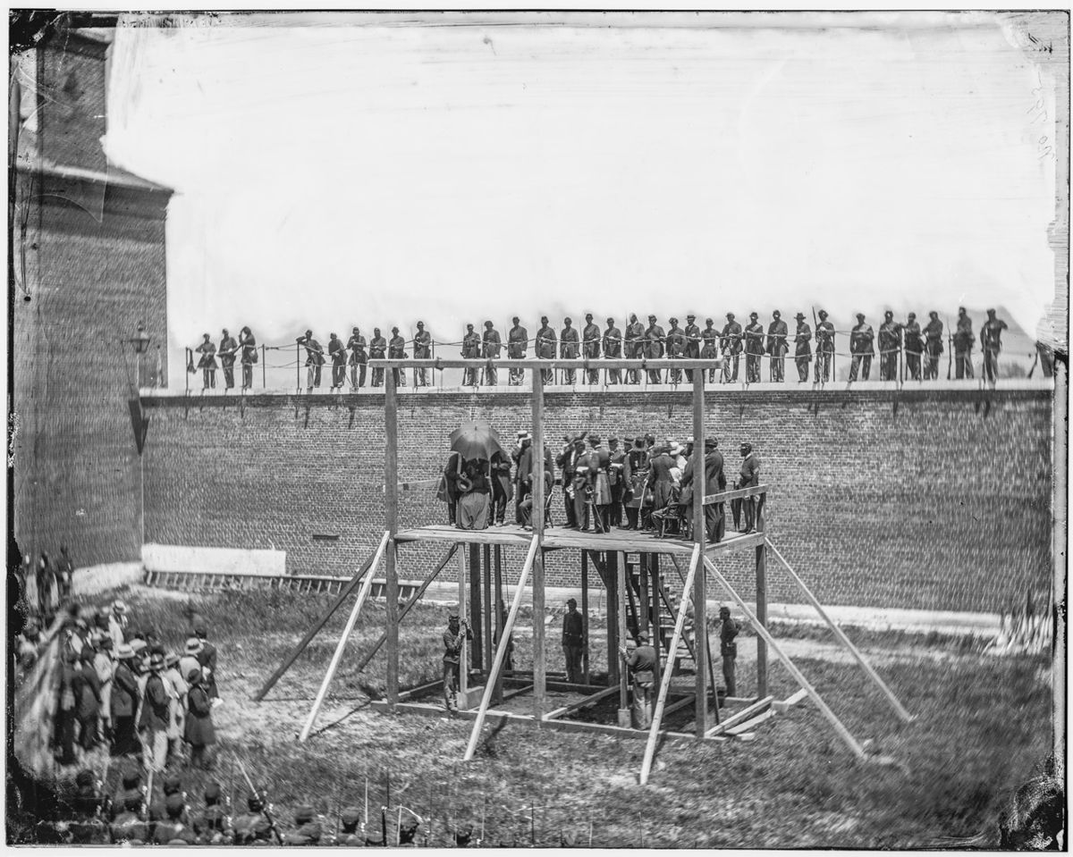Washington, D.C. The four condemned conspirators (Mrs. Mary Surratt, Payne, Herold, Atzerodt), with officers and others on the scaffold; guards on the wall. (Library of Congress)
