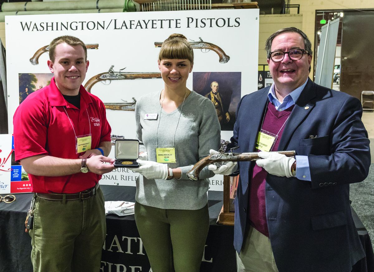 Fort Ligonier’s Matthew Gault and Erica Nuckles, the Director of History and Collections, hold the Gold Medal Award #4 that was presented for the Washington-Lafayette Pistols, one of which is held by Philip Schreier, Senior Curator NRA Museums.
