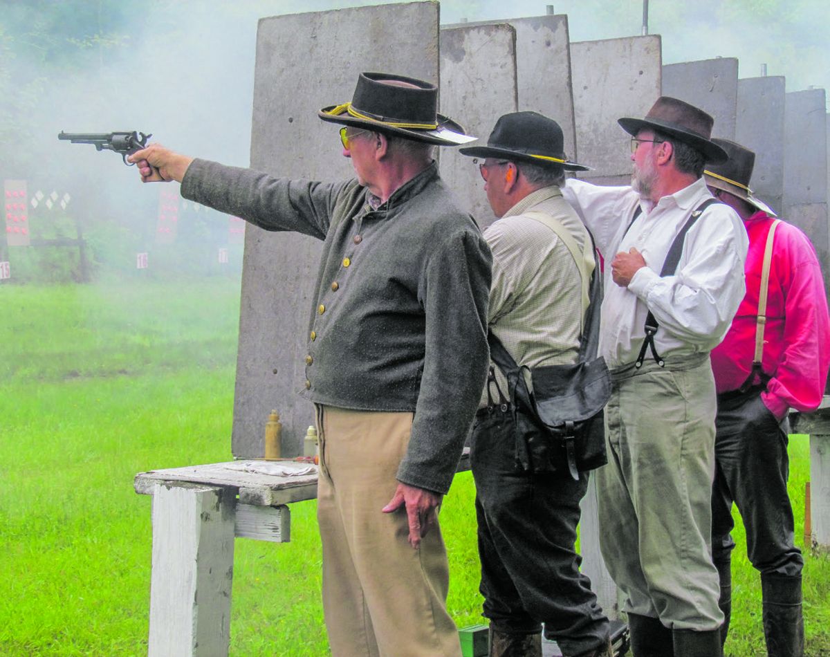 Sixty four-member teams competed in the revolver match. Muzzle blast and percussion cap fragments necessitate the dividers between each shooter.