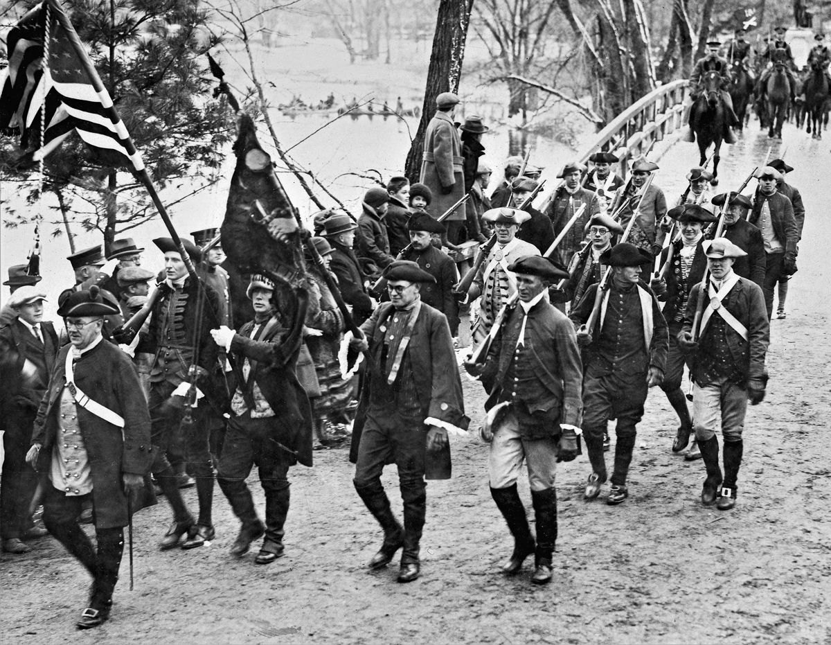 “Militiamen” march across Concord Bridge in 1925. Note “Indians” in canoes in left background.