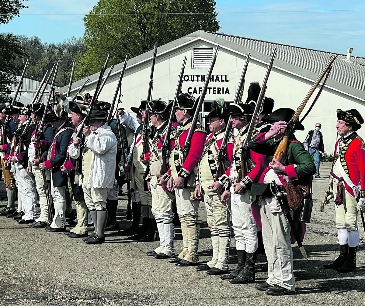Reenactors of the Revolutionary War: Continental Army and British soldiers in formation.