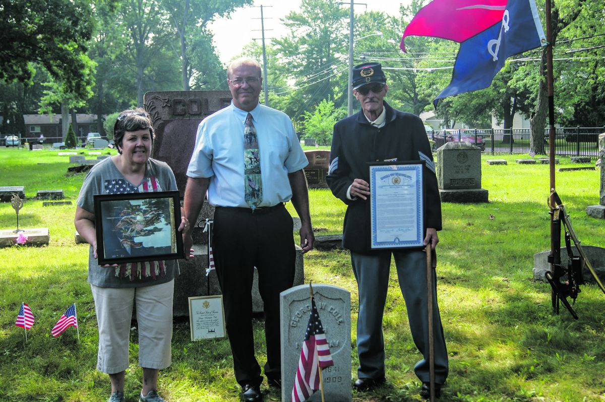 Matt Van Acker, Chairman of Michigan’s “Save the Flags” program, presents a photo of the 1st Michigan Cavalry’s regimental flag to Mary Lewis (left) and a Legislative Tribute certificate to Jack Haus (right). Mary is the great granddaughter of trooper George Washington Cole.