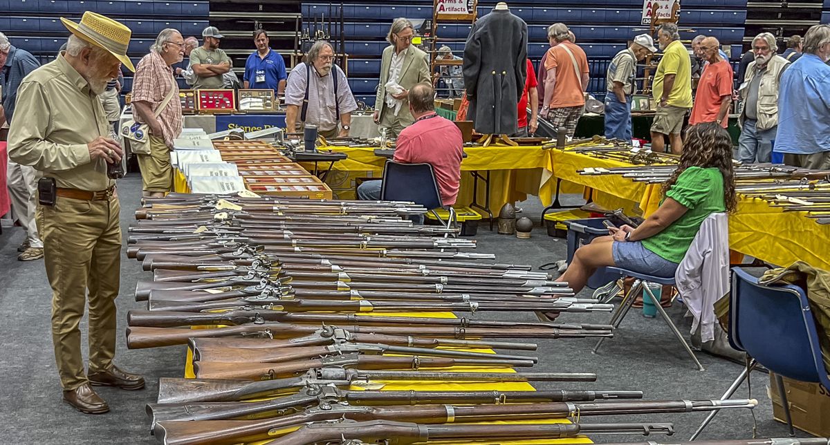 Rafael Eledge (orange shirt) brought an extensive collection of antique firearms for sale.
